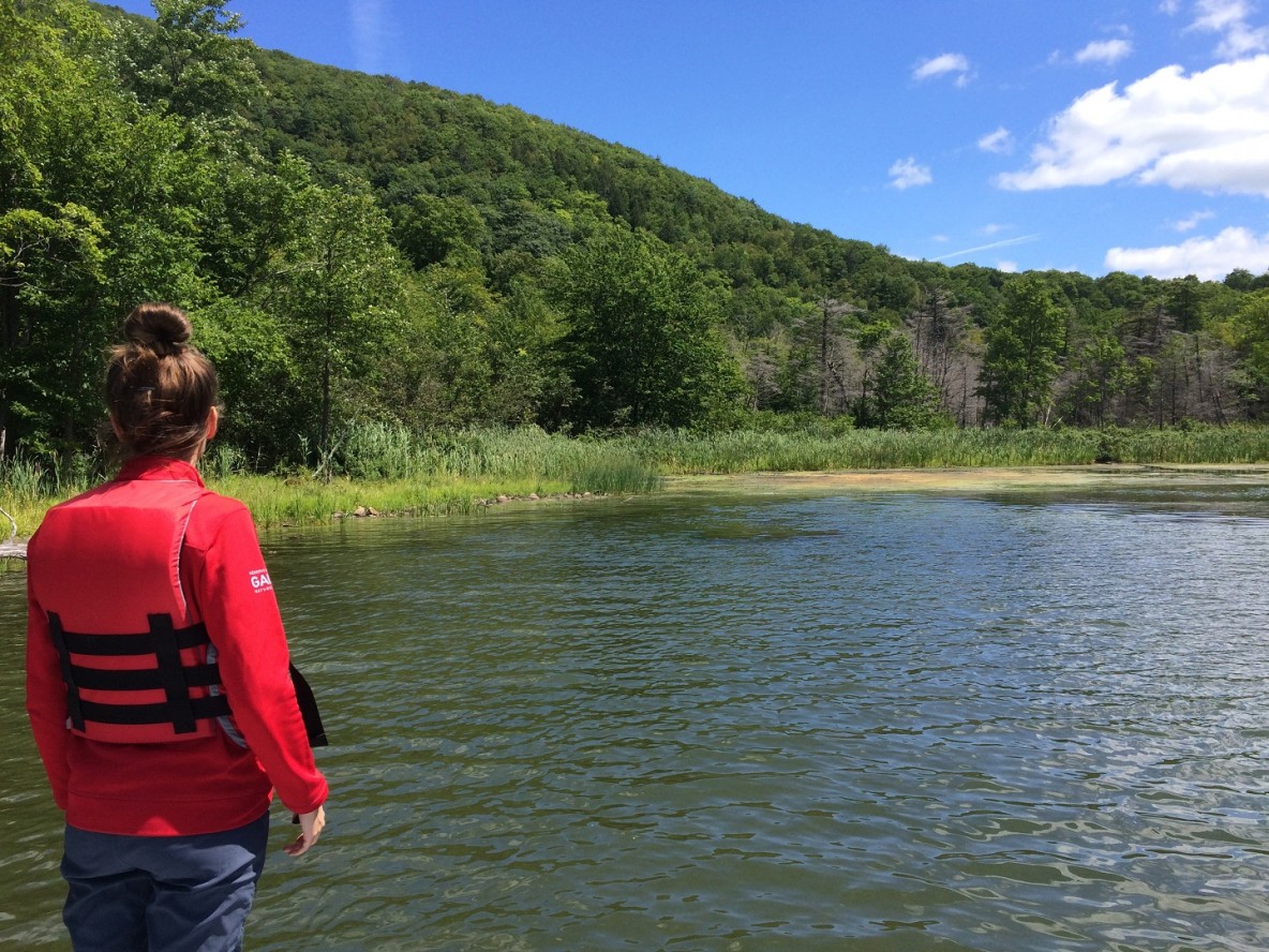 A Gault Nature Reserve intern on the shore of Lake Hertel