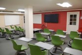 Une salle de classe avec des chaises vertes