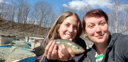Two researchers hold a fish
