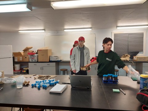Philippe (à gauche) et Seonaid (à droite) sont derrière une table où se trouve du matériel de laboratoire.