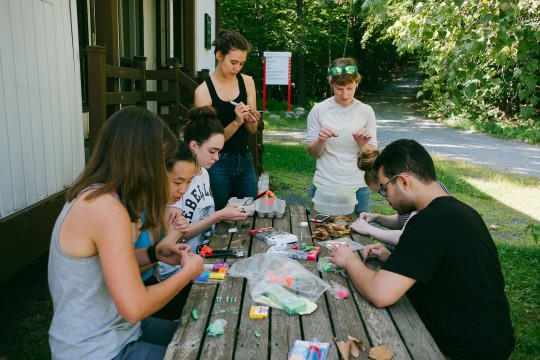 Six étudiants en biologie travaillent autour d'une table de picnic à l'extérieur avec leur enseignante Anna Hargreaves.