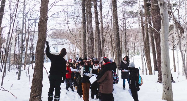 David Maneli shows a group of students how to recognize a tree by its bark in winter.