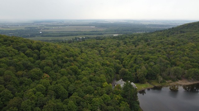 Aerial view of the shore of Lac Hertel with the sprawling fields of Monteregie in the background.