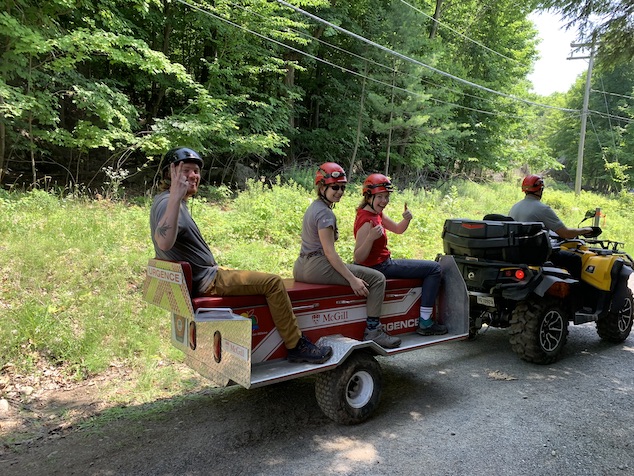 Three university students sitting behind an all-terrain vehicle.